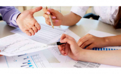 Hands with paperwork and pens