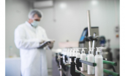 A production manager checks a pharmaceutical creams production line